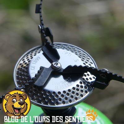 le support popote du réchaud Optimus Crux se replie sur le bruleur pour un meilleur gain de place