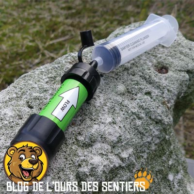Une seringue va permettre d'envoyer de l'eau propre en contre pression dans un filtre paille sawyer mini en vue de son nettoyage