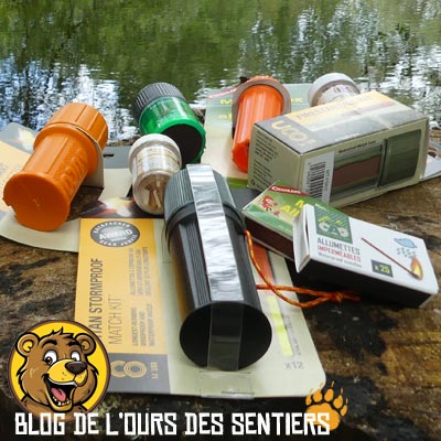 Pour la survie ou le bushcraft, Vue d'une panoplie de boites d'allumettes de survie en attente de test par l'Ours des Sentiers