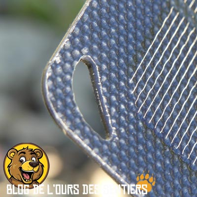 Des oeillets présents aux extrémités des volets solaires permettent de fixer le chargeur sur un sac à dos