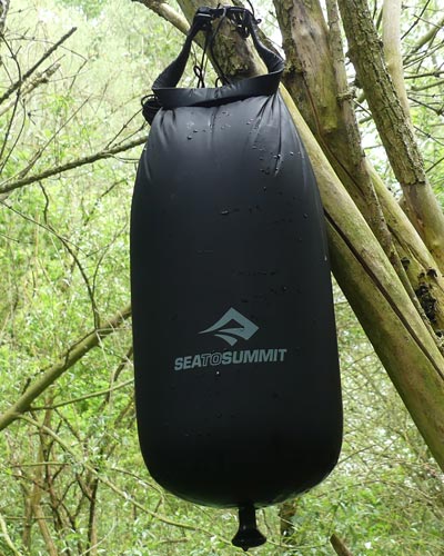 Il est assez facile de suspendre la douche solaire portable Sea to Summit à un arbre grace à sa sangle roll-top robuste