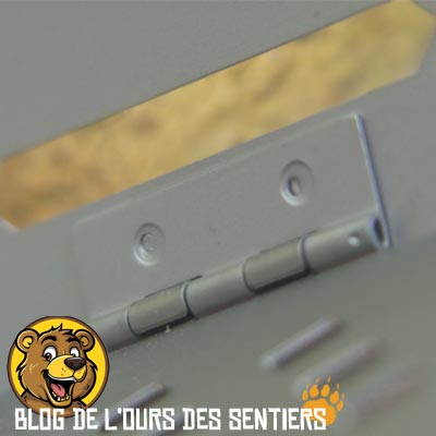 Vue de la charnière de fixation et rotation entre la grille du foyer de combustion et un volet latéral