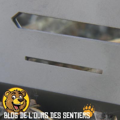 Vue de la fente de logement pour l'ergot de maintien de la grille du foyer sur un volet latéral